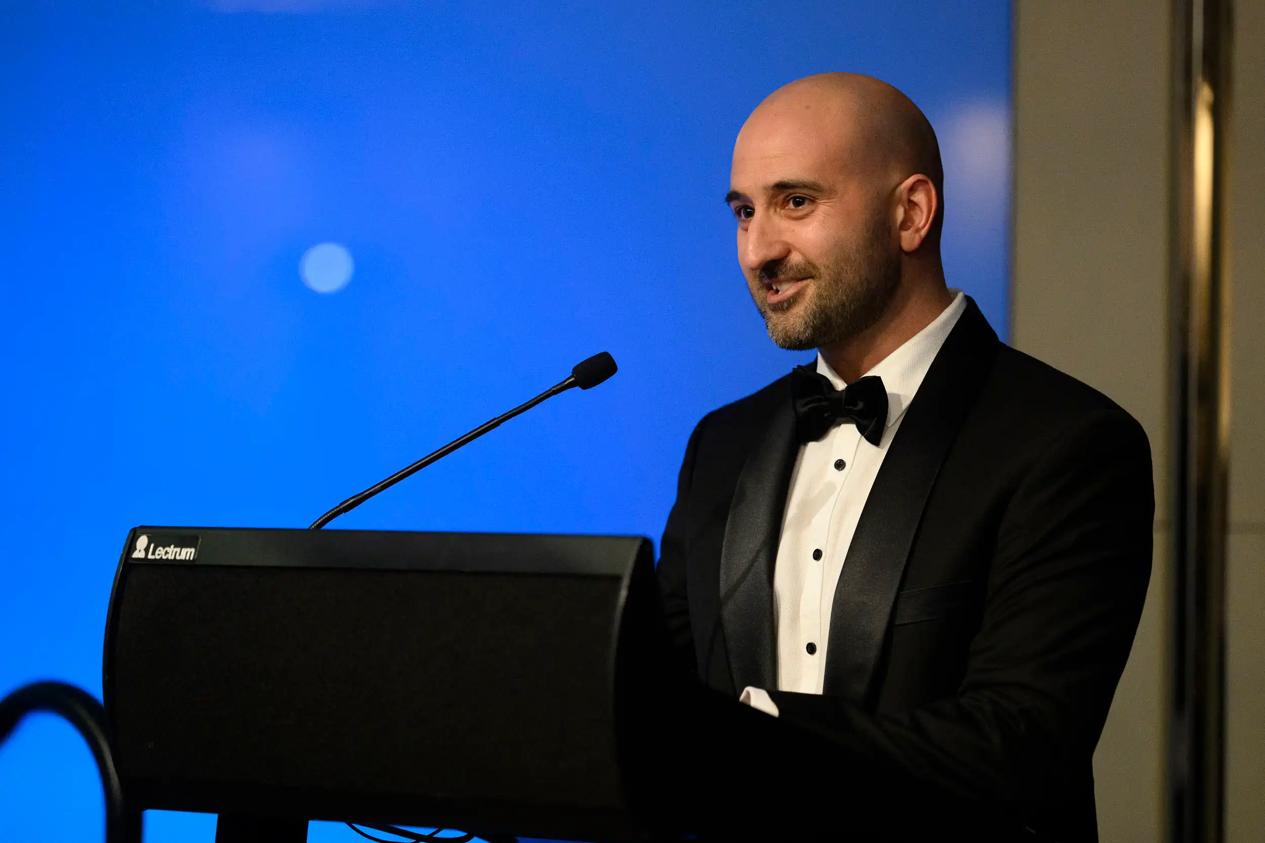Doctor Billy Stoupas speaking at a formal event